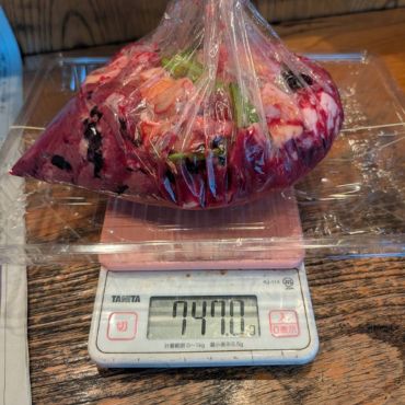 炭焼雷の食品ロス調査で、廃棄する食材を袋に入れ、デジタルはかりで重量を計測している様子